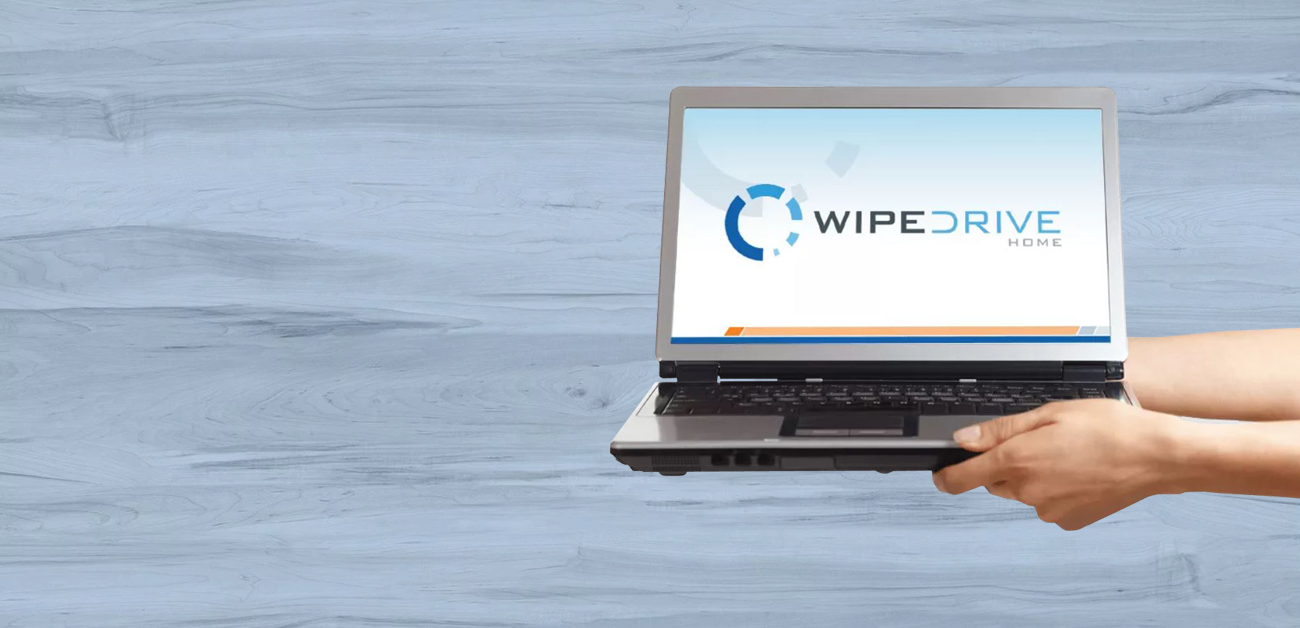 Two hands were holding a laptop on whose display is a WipeDrive Home interface